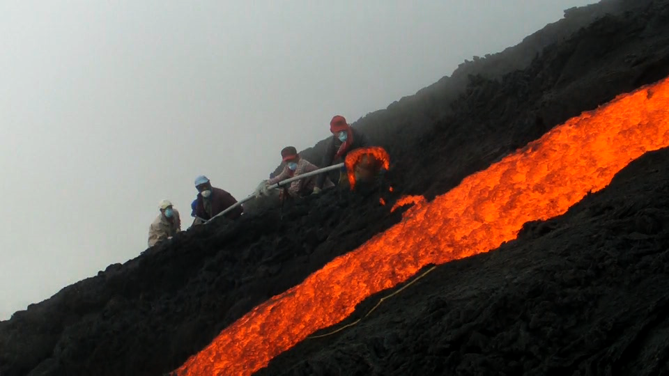 danny with his crew casting lava directly from a flow on volcano pacaya, guatemala. 2010.